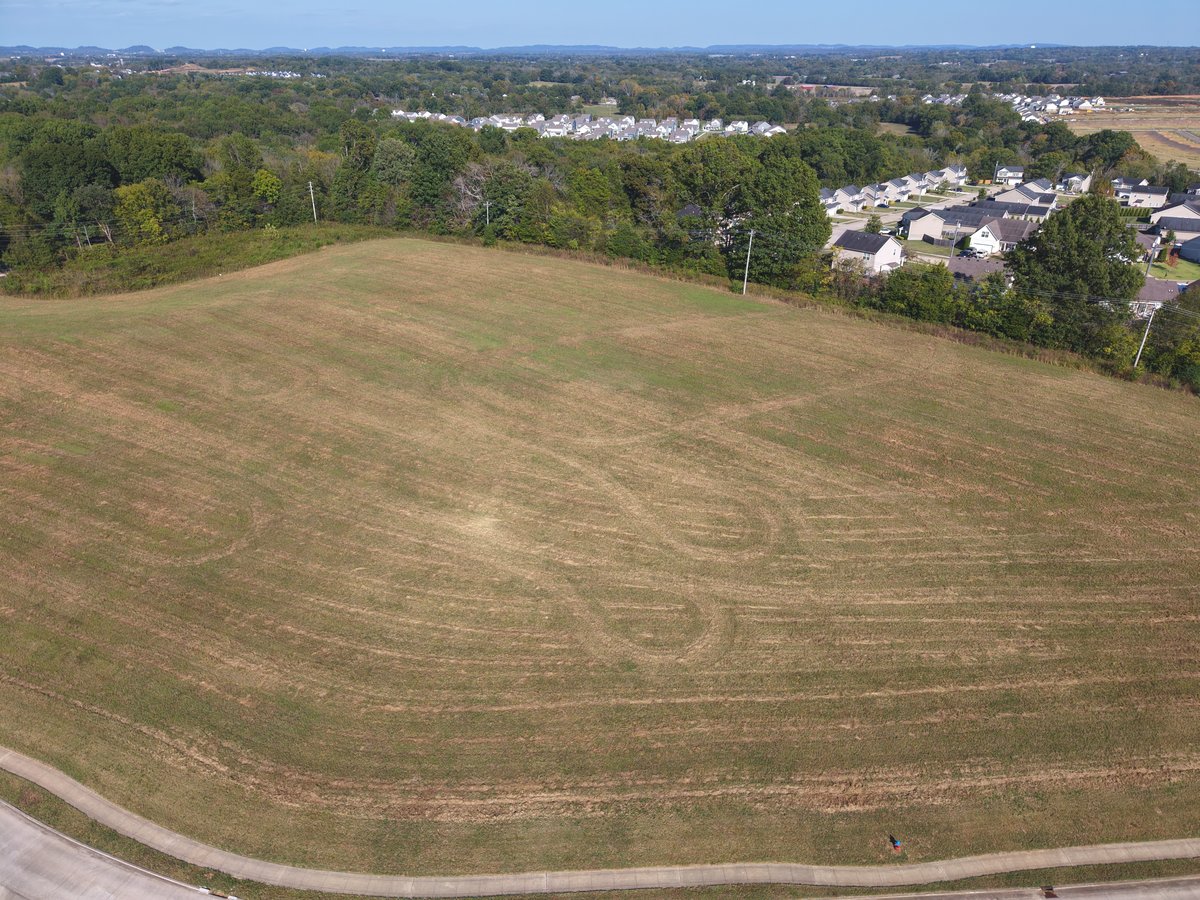 Aerial view of a mowed pasture beside a tree line in Columbia, Tennessee.