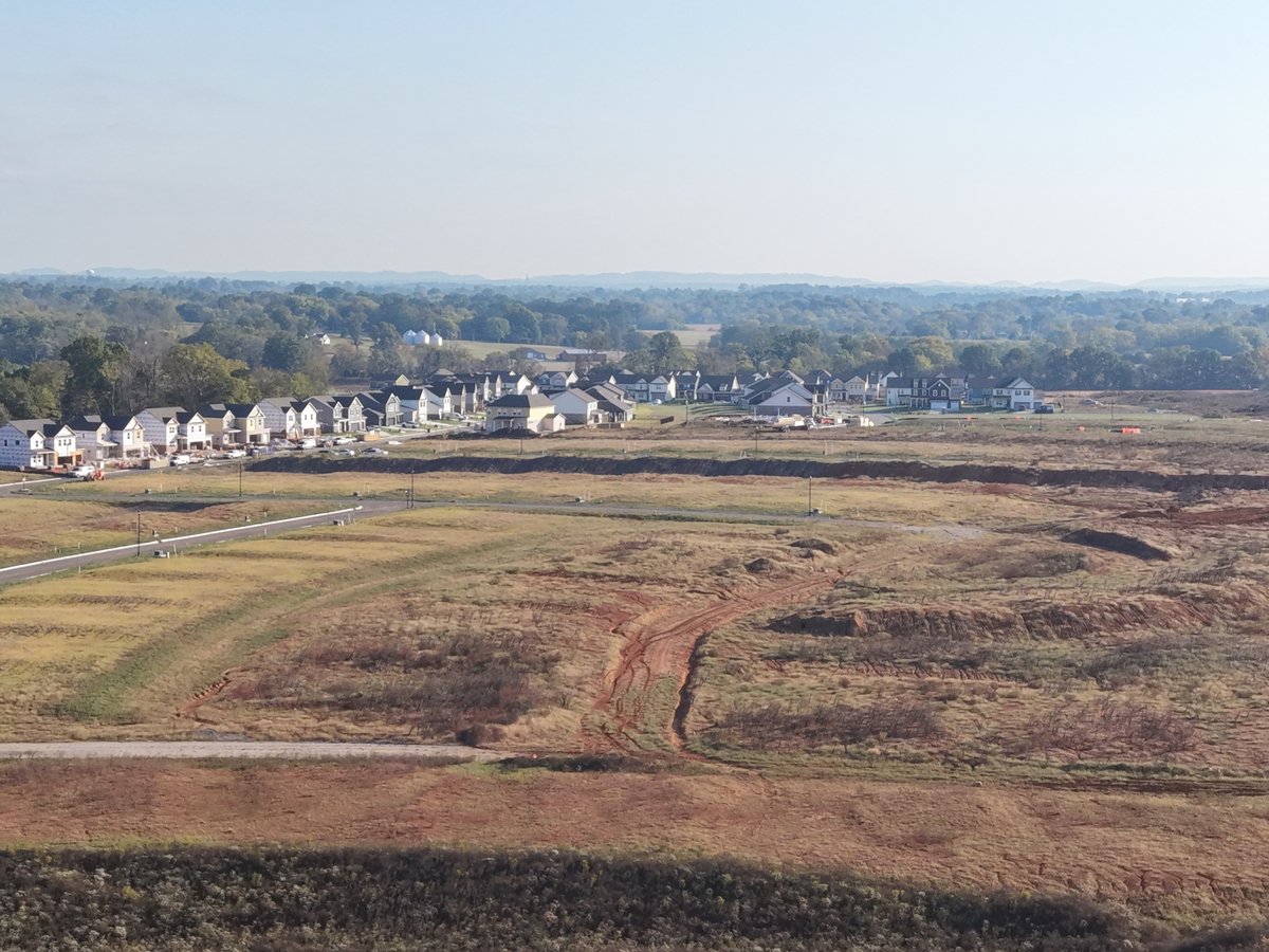 Oblique aerial view of new homes beyond graded lots in Maury County, Tennessee.